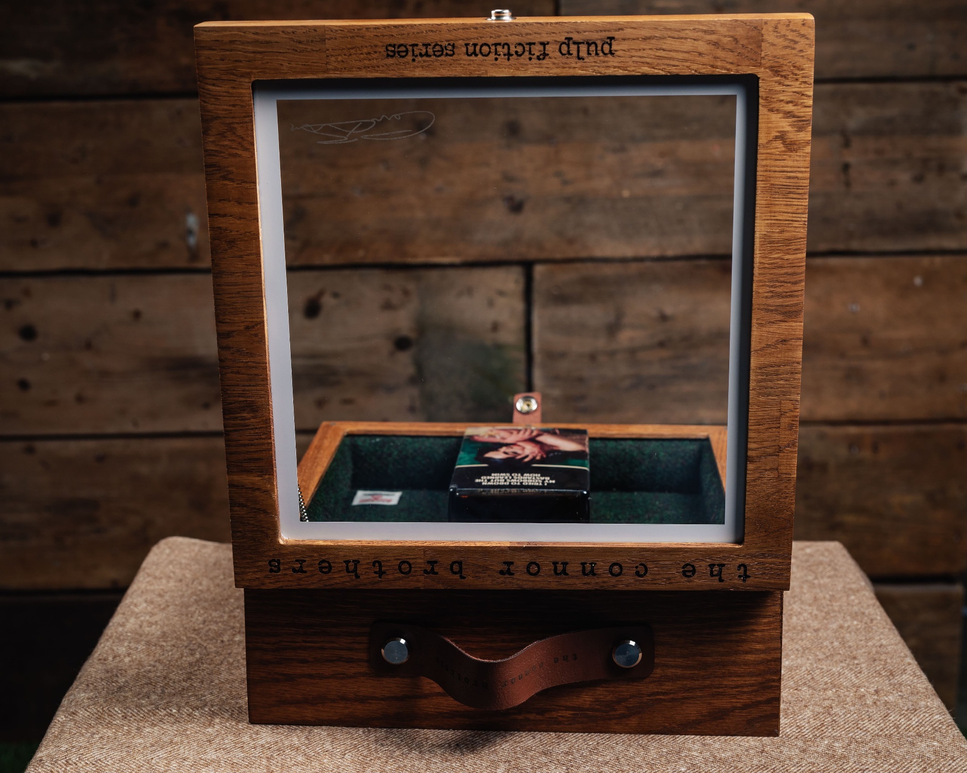 Hinged lid open — artist signature on the inside, leather pull on the drawer below.