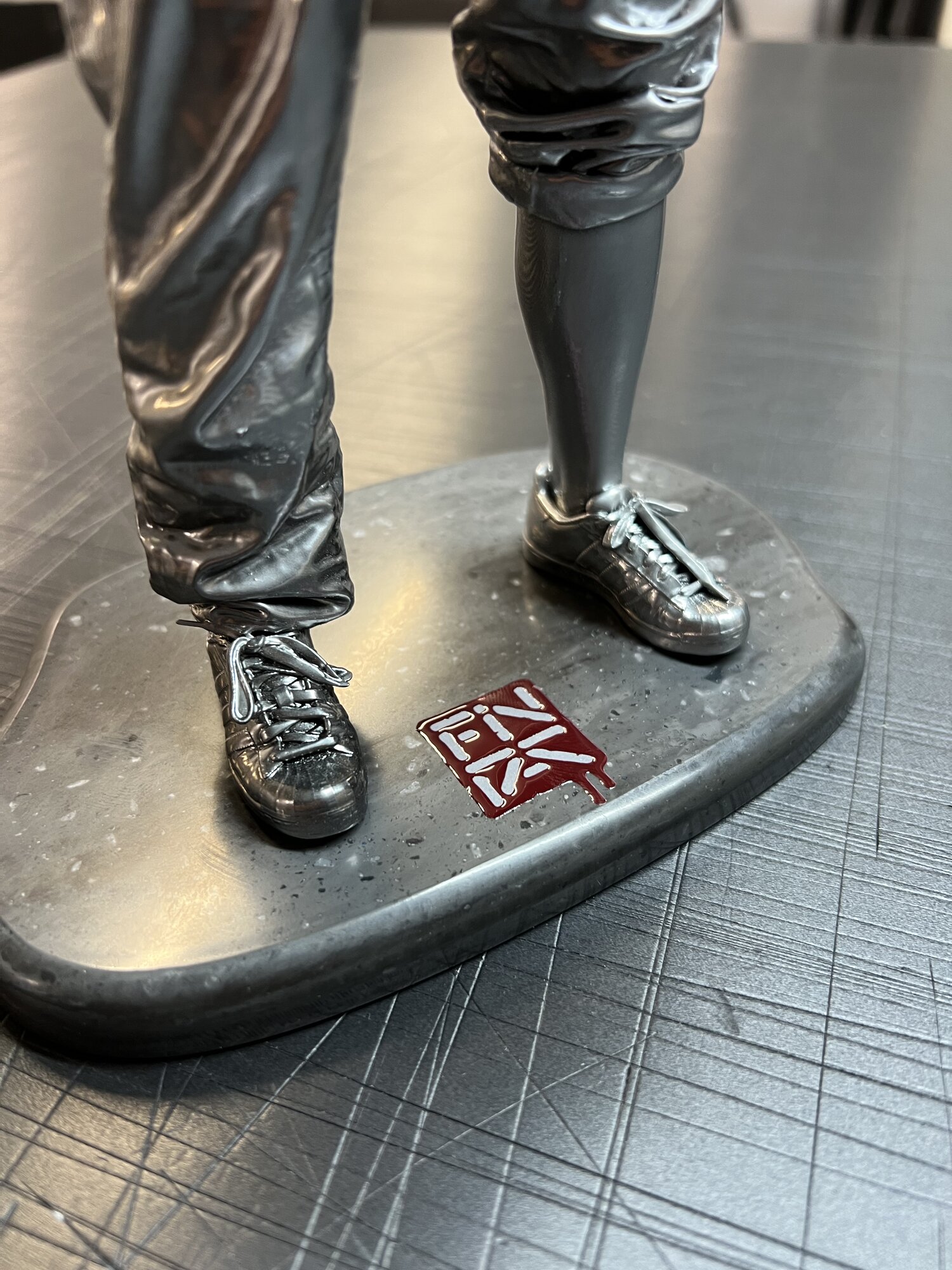 Plinth detail — Corian base with the embossed Fin DAC mark, UV printed in red and white.