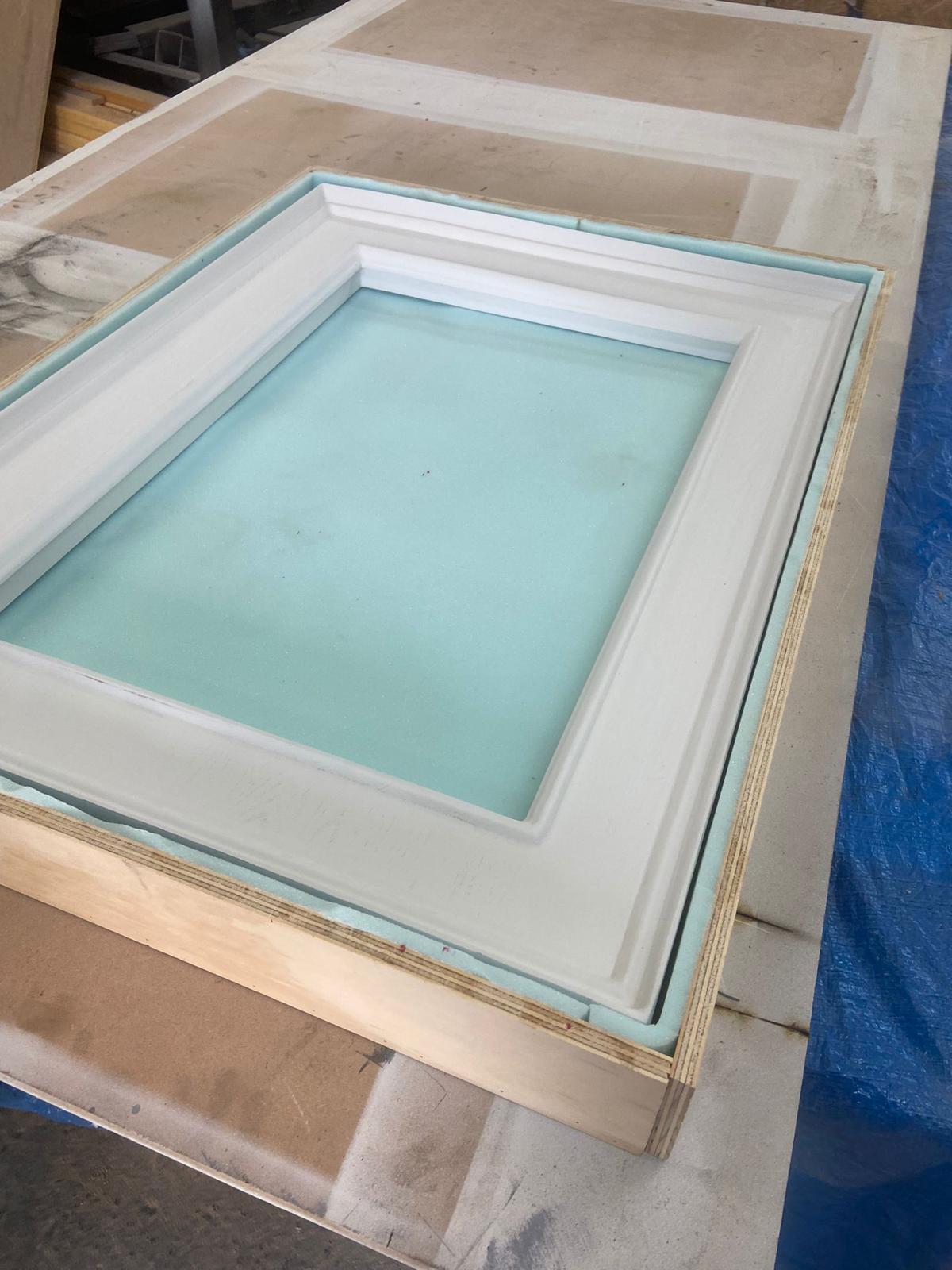 Held in the paint jig — final prep before the artists take over.