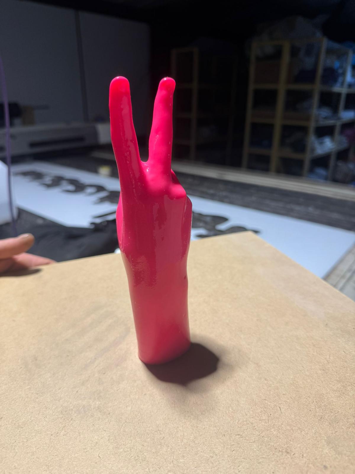 Reverse profile — fingers from behind, surface of the original cast still legible.