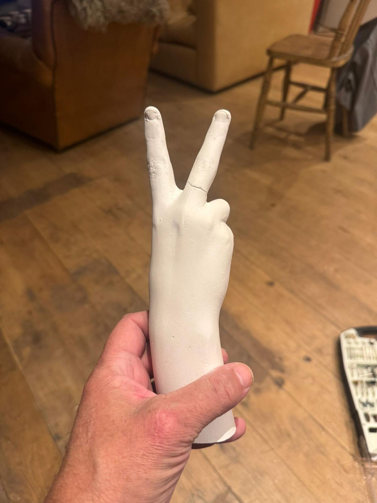 The original — child's hand plaster cast by Dave, held in the studio before scanning.